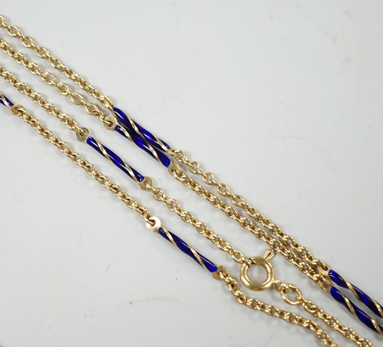 An early 20th century yellow metal overlaid, two colour enamel and citrine set watch key, on a 585 yellow metal and two colour enamel twin strand albertina, overall 88cm, gross weight 21.5 grams.